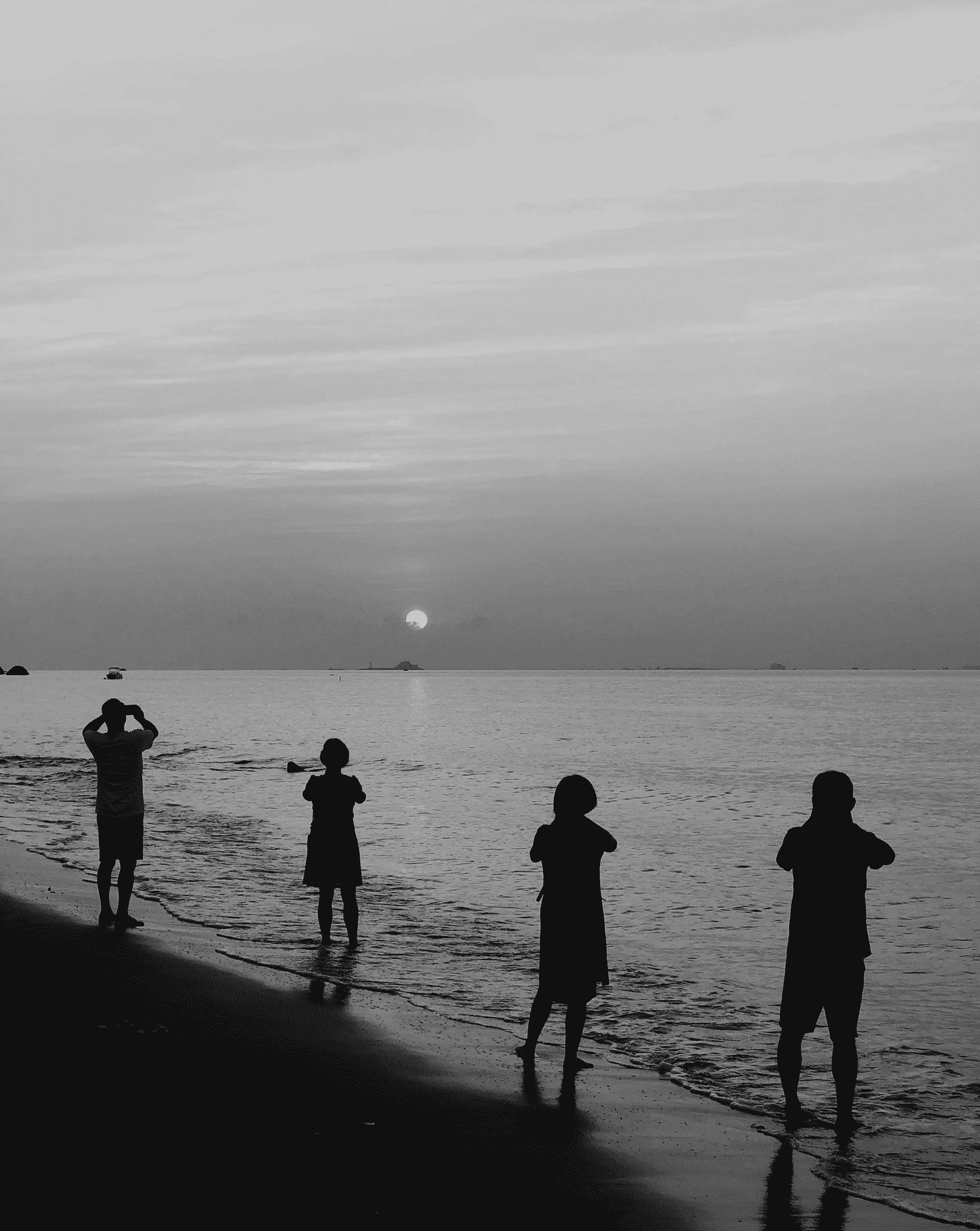 Four people photographing the sunrise, emphasizing repeated actions for thematic coherence, taken with an iPhone.